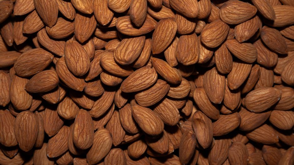 A detailed close-up view of raw almonds, showcasing the texture and natural color.