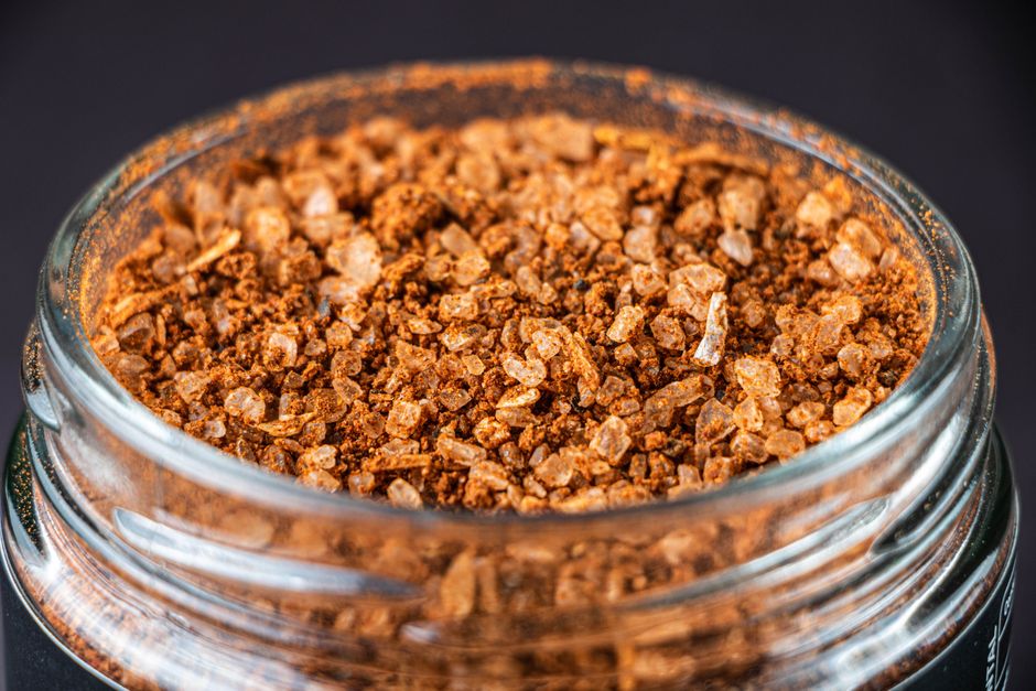 Macro shot of mixed spices in a glass jar, ideal for culinary use.