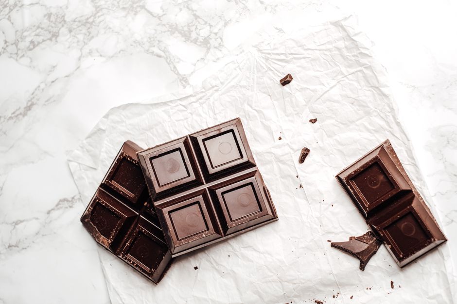Elegant display of dark chocolate bars on a white marble surface. Perfect for dessert lovers.